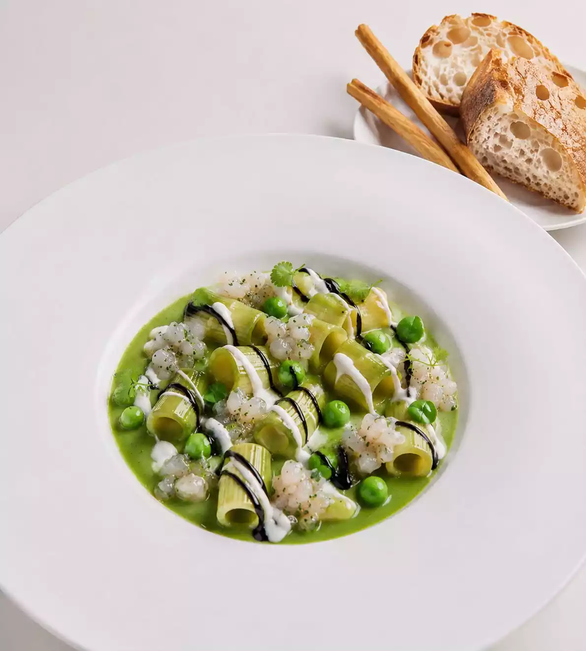 Pasta verde con piselli e crudo di mare